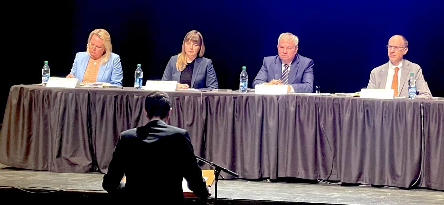 This image has a person speaking to a panel that is on a stage. The four individuals on stage are taking notes. This image is from the NTIA Listening Session in 2023 that was hosted at the University of Notre Dame.